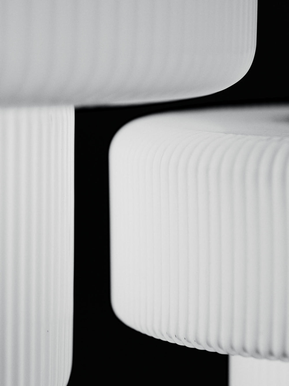 Close-up of the lamp's rippled white shades against a black background