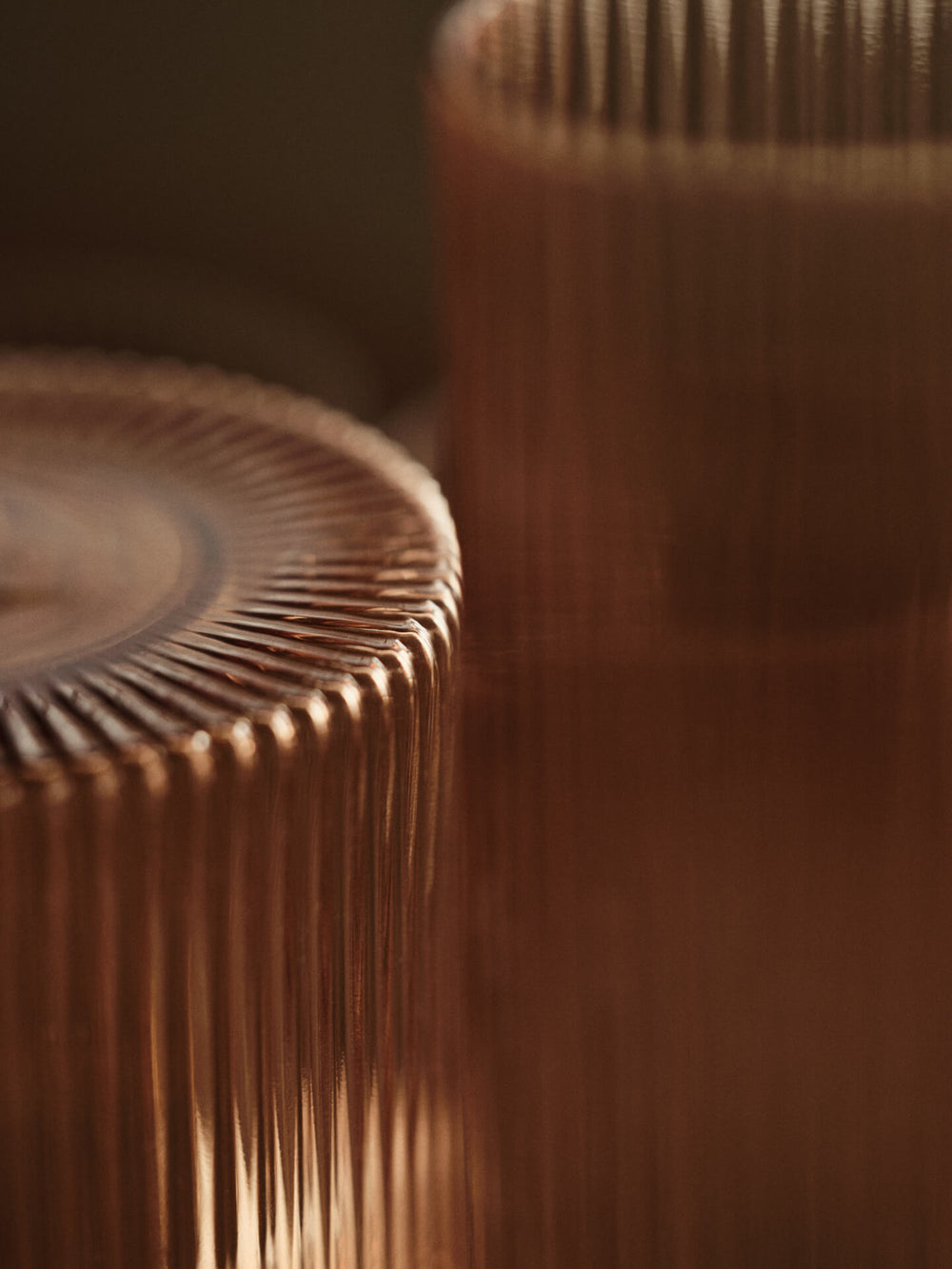 Close-up of the ribbed rim and rippled surface of the blush glass and carafe